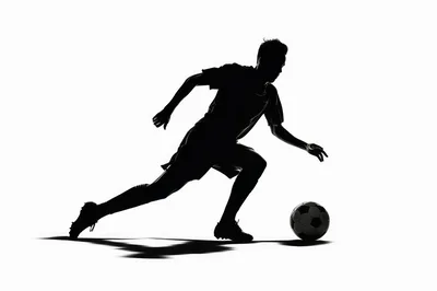 Silhouette Of A Soccer Player Dribbling A Ball