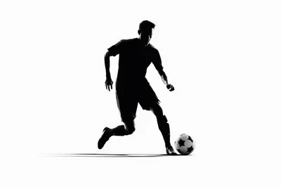 Silhouette Of A Soccer Player Dribbling A Ball