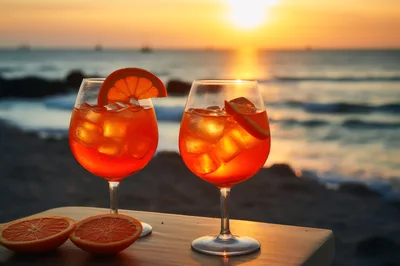 Two Aperol Spritz Cocktails On A Beach At Sunset