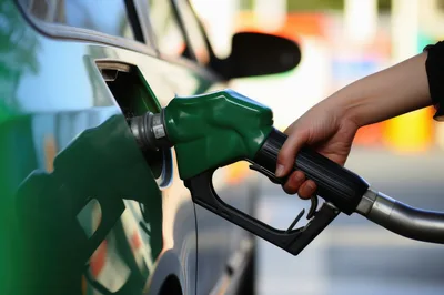 Person Refueling A Green Car At A Gas Station