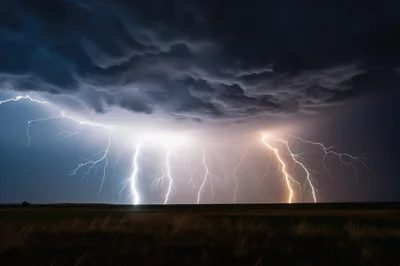 Multiple Lightning Bolts Striking Over A Dark Prairie
