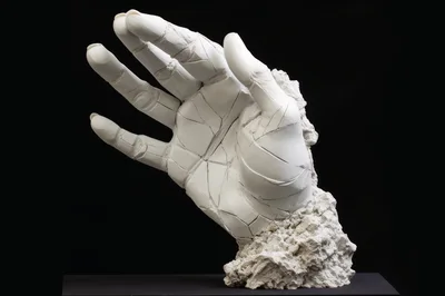 Fragmented White Marble Hand Sculpture On Black Background