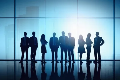 Silhouettes Of Business Professionals Standing In Office