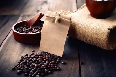 Coffee Beans and Blank Paper Tag on Wooden Table