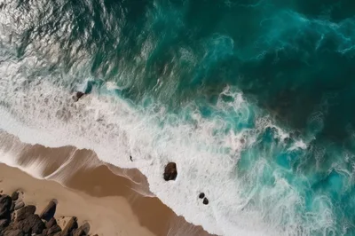 Aerial View Of Turquoise Ocean Waves Crashing On Beach