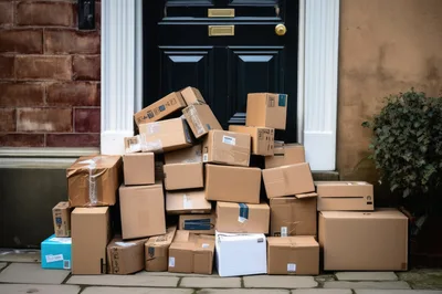 Large Pile Of Cardboard Delivery Boxes At Front Door