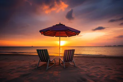 Two Beach Chairs Under Umbrella At Sunset