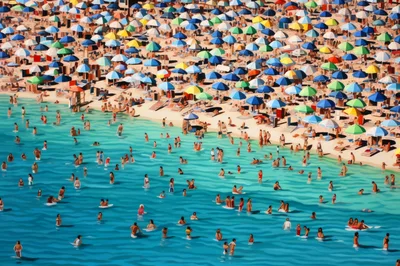 Crowded Tropical Beach With Colorful Umbrellas And Swimmers
