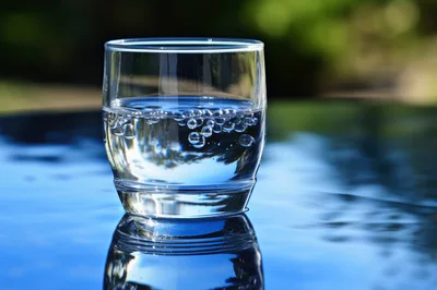 Glass Of Sparkling Water On A Reflective Surface