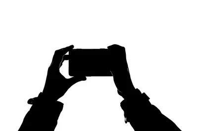 Silhouette Of Hands Holding A Smartphone