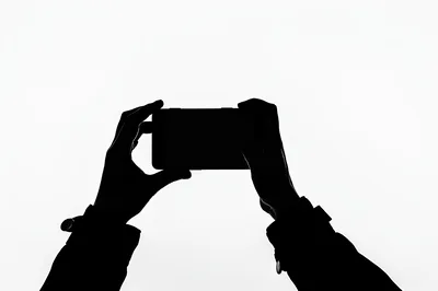 Silhouette Of Hands Holding A Smartphone