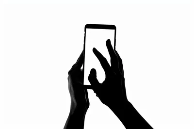 Silhouette Of Hands Interacting With A Smartphone Screen