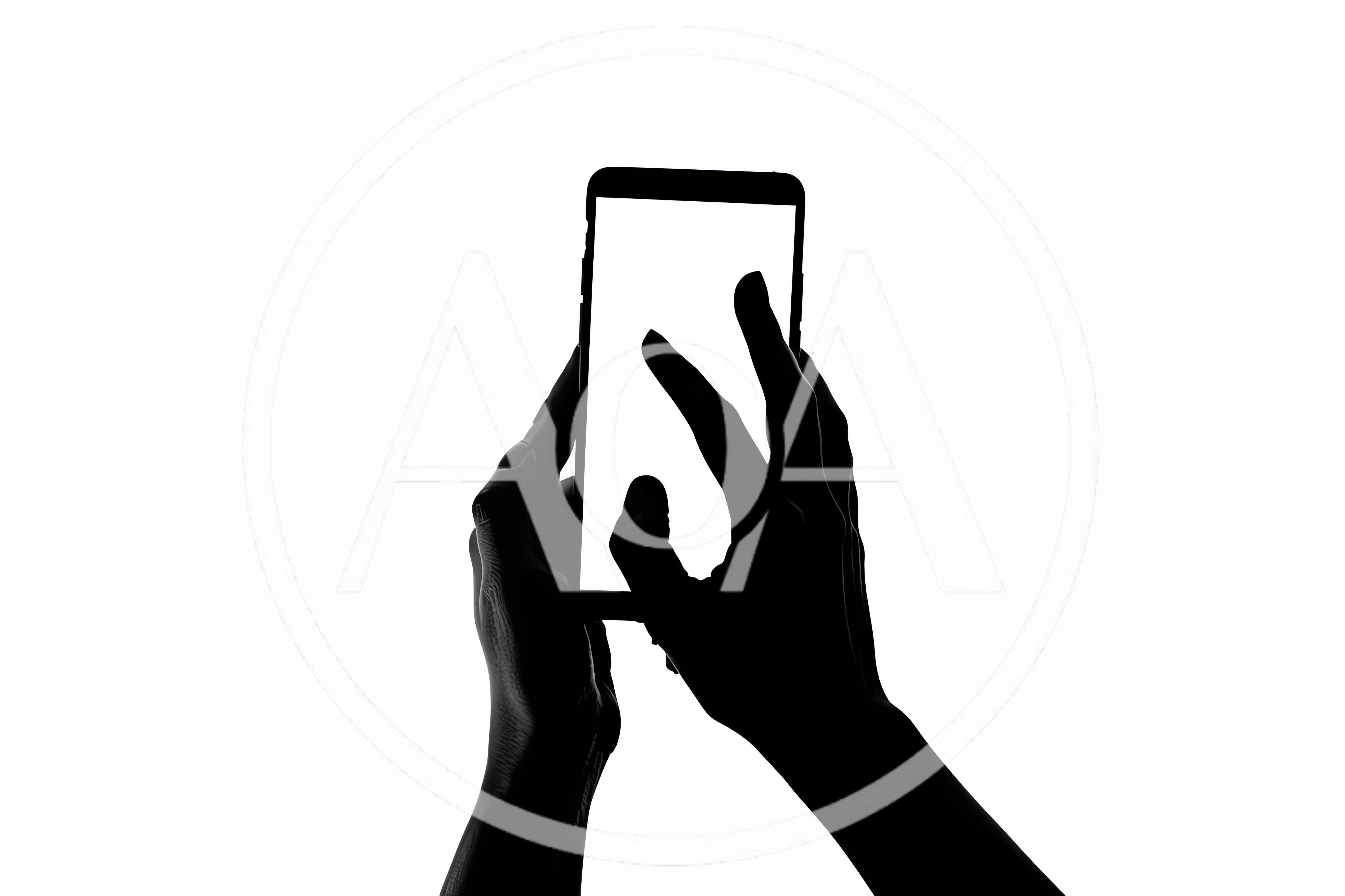 Silhouette Of Hands Interacting With A Smartphone Screen