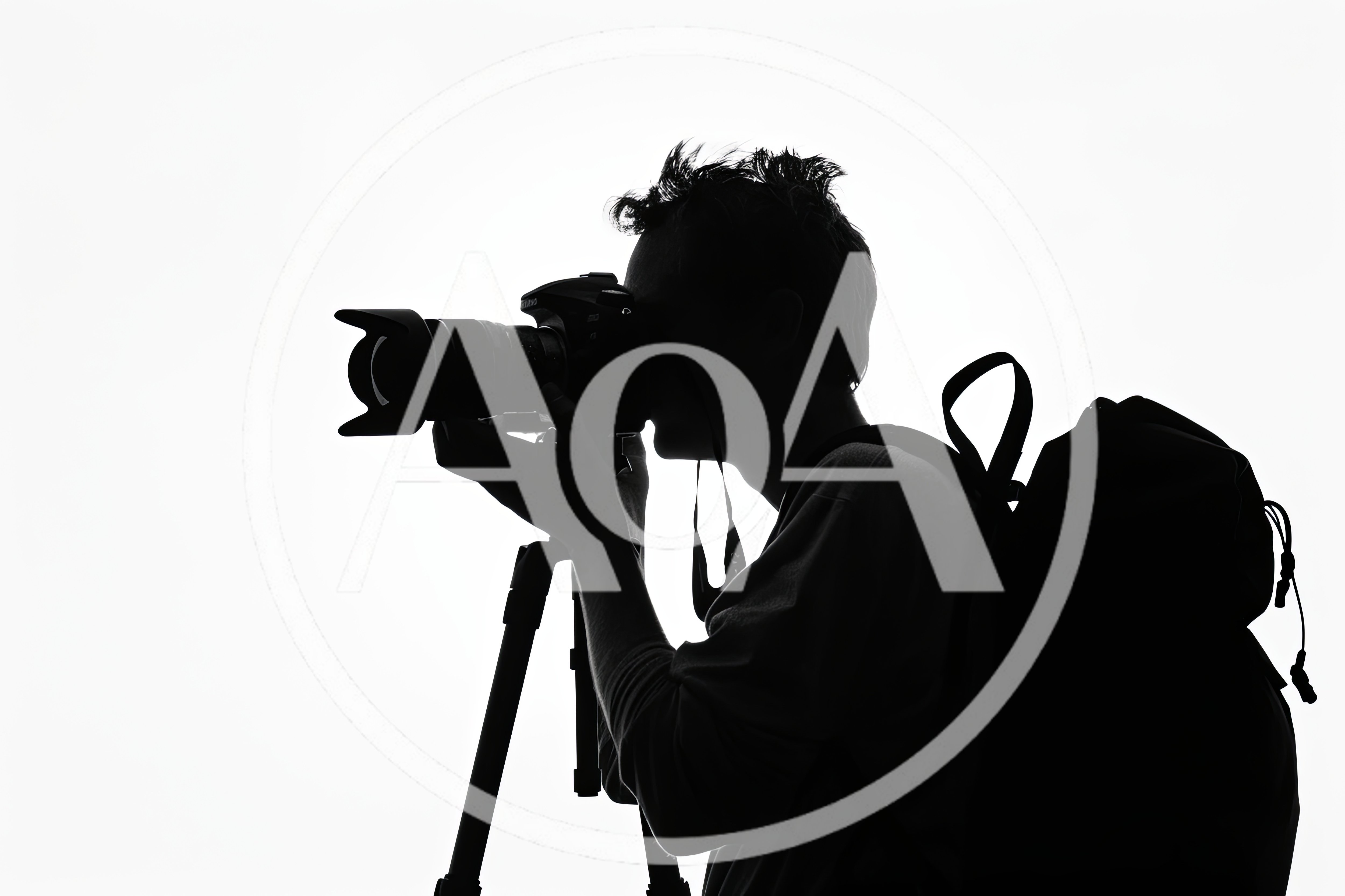 Silhouette Of A Photographer Using A Camera On Tripod