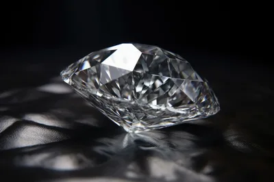 Brilliant Cut Diamond Resting On Dark Textured Surface