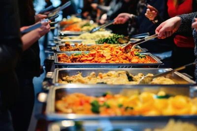 People Serving Food At A Buffet Line