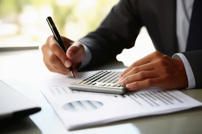 Business Professional Calculating Financial Data With Pen And Calculator