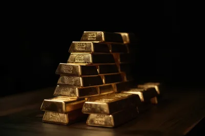 Stack Of Shiny Gold Bars On Dark Surface