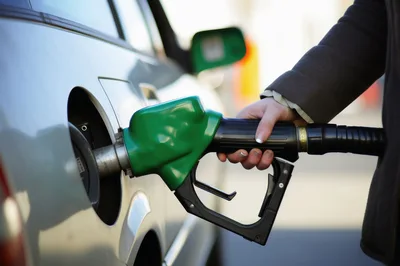 Person Refueling A Silver Car At A Gas Station