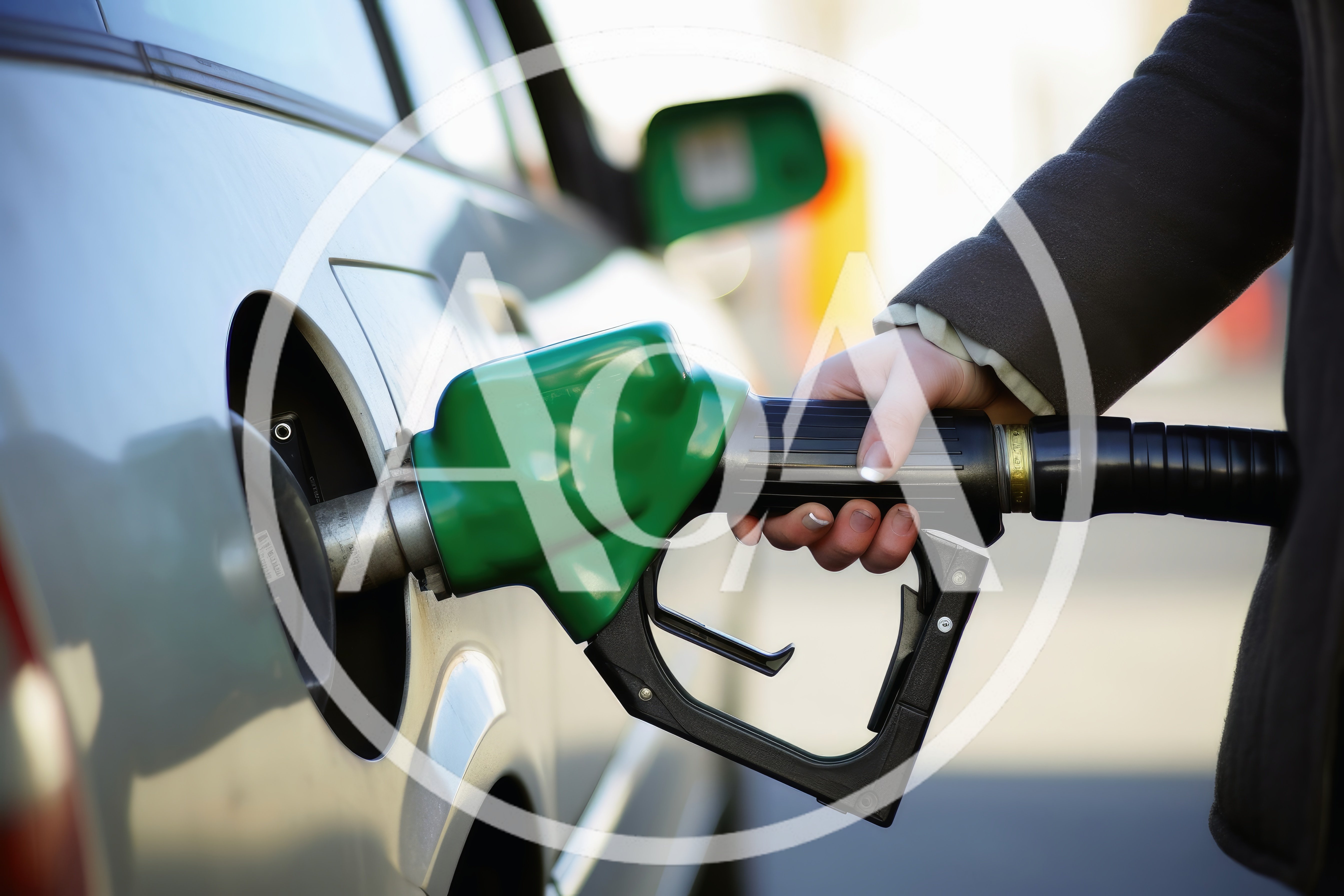 Person Refueling A Silver Car At A Gas Station
