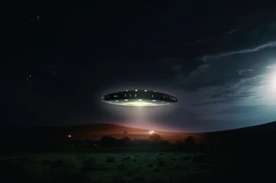 UFO Hovering Over A Dark Rural Landscape At Night