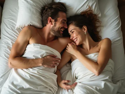Happy Couple Laughing Together In Bed