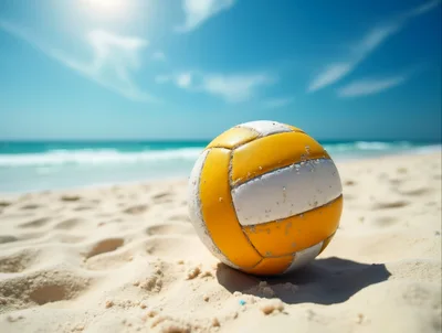 Yellow And White Volleyball Resting On Sandy Beach