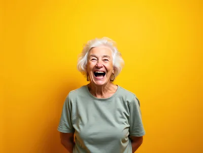 Happy Elderly Woman Laughing Against Yellow Background