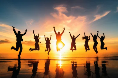 Group Of Friends Jumping On Beach At Sunset