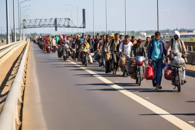 Migrants Traveling On Motorcycles Along A Highway Bridge