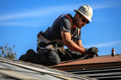 Construction Worker Installing Shingles on Residential Roof