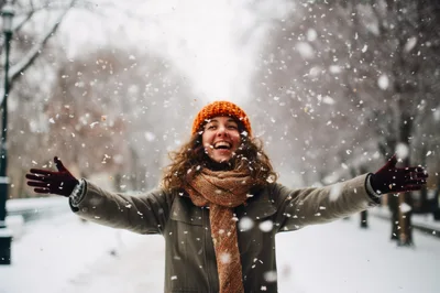 Happy Woman Enjoying Snowfall In A Winter Park