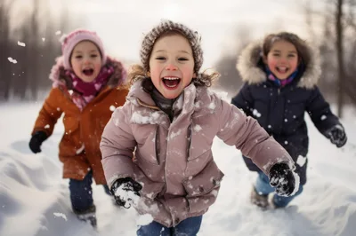 Three Happy Children Running Through Snowy Winter Park