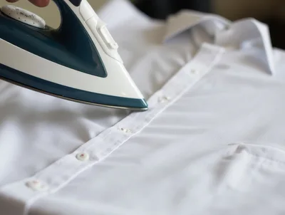 Person Ironing A Crisp White Dress Shirt
