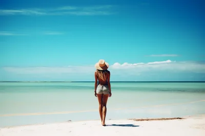 Woman Standing On Tropical Beach Wearing Straw Hat
