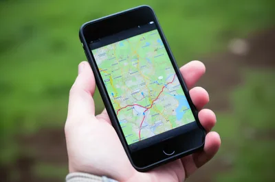Person Holding Smartphone Displaying Digital Map Navigation