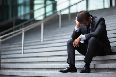 Stressed Businessman Sitting Alone On Outdoor Office Stairs