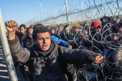 Migrants Protesting At Border Fence With Barbed Wire