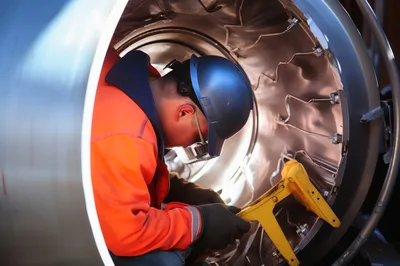 Industrial Worker Inspecting Large Metal Turbine Component