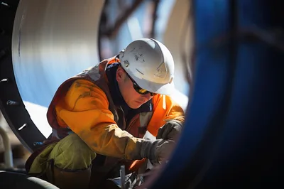 Industrial Worker Welding Inside Large Metal Pipe