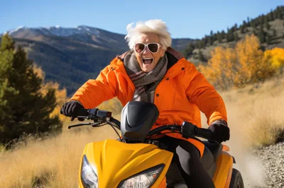 Elderly Woman Riding Yellow Scooter Through Mountain Landscape