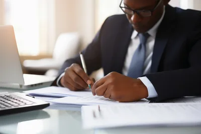 Professional Businessman Signing Documents At Office Desk