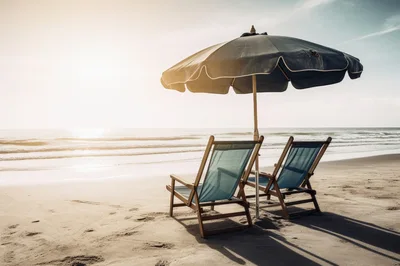 Two Empty Beach Chairs Under Umbrella At Sunset