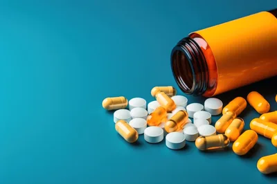 Pills and Capsules Spilled from an Orange Bottle