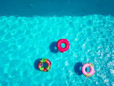 Three Colorful Inflatable Pool Floats In Swimming Pool