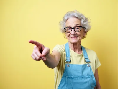 Senior Woman Pointing Forward Against Yellow Background