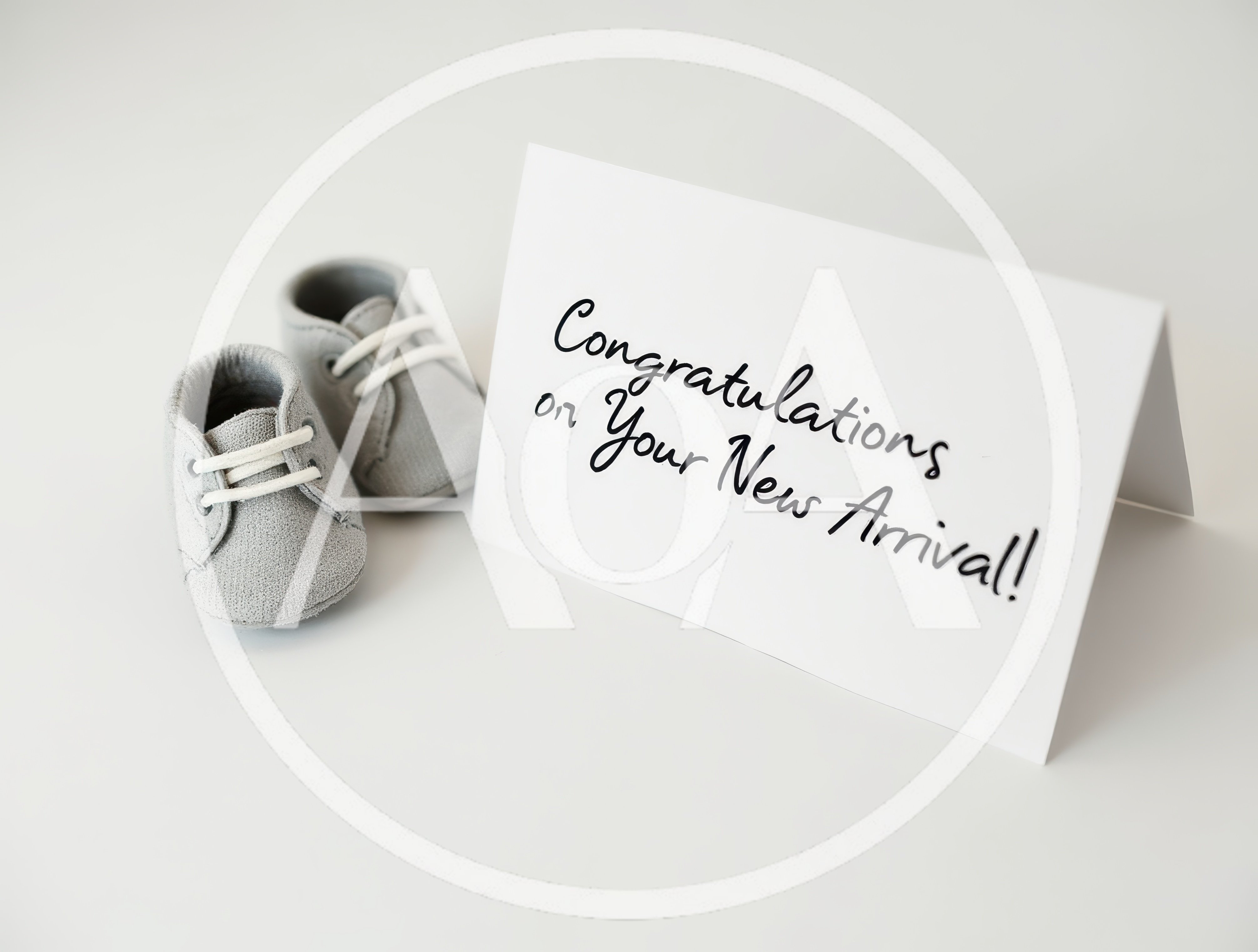 Baby Shoes Next To A Congratulations Card