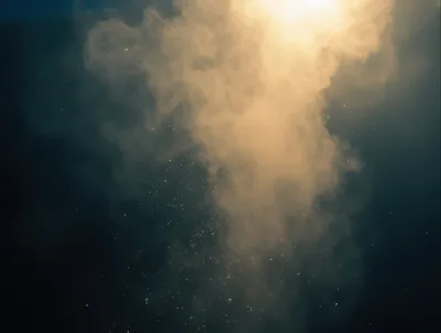 Golden Smoke And Floating Embers Against Dark Background