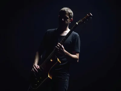 Musician Playing Electric Guitar In Dark Studio