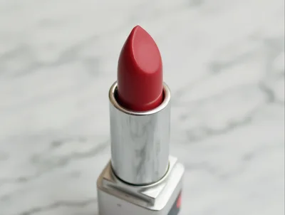 Red Lipstick Tube Standing On Marble Surface